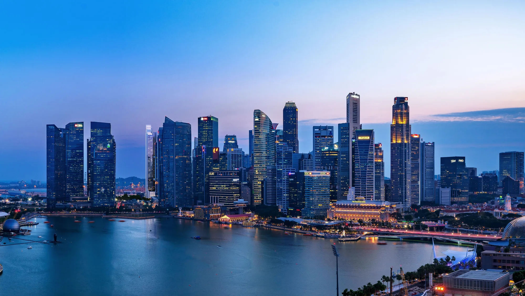 Marina Bay, illustrative photograph: the financial district skyline across Marina Bay at dusk, office towers lit above the waterfront