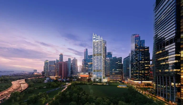 W Residences Marina View, artist’s impression: the slim pale tower lit at dusk among the Marina Bay skyline, with the green of the future Central Linear Park in front